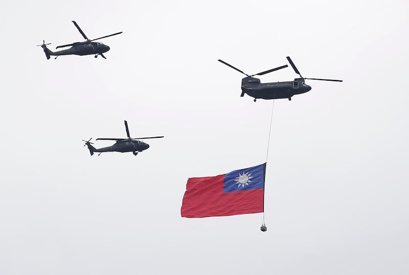 A helicopter flies over the President Office with the Taiwan flag during National Day celebrations in Taipei, Oct. 10, 2024.