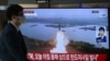 A man walks past a television screen showing a news broadcast with file footage of a North Korean missile test, at a train station in Seoul on October 31, 2024.