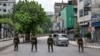 FILE - Bangladesh soldiers stand guard along the street in Dhaka on July 20, 2024, after days of protests against government job quotas across the country. Journalists report being harassed, forced to delete images from their cameras, and injured while covering the unrest.