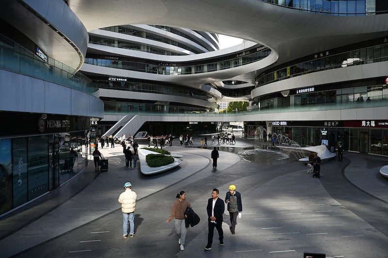 People walk in a quiet shopping mall in Beijing on November 3, 2024.