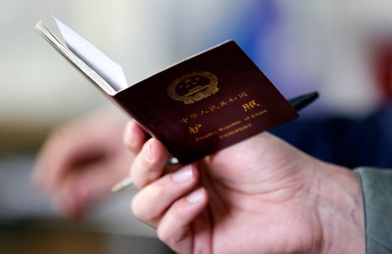 A police officer checks the passport of a Chinese immigrant in Prato, Italy, Dec. 9, 2013.