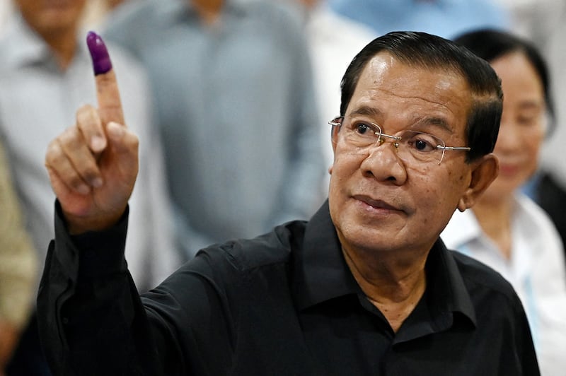 Cambodia's former Prime Minister Hun Sen shows his inked finger after voting at a polling station during the Senate election in Takhmao city, Kandal province on Feb. 25, 2024.