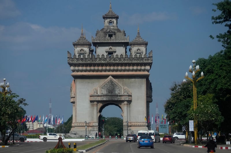 Cars drive in front of the Patuxay victory monument in Vientiane.