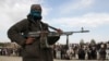 FILE - A member of the Taliban and other people stand at the site of a public execution in Ghazni province, Afghanistan, April 18, 2015. A convicted murdered is scheduled to be executed on Nov. 13, 2024, in Gardez, in the country's Paktia province.