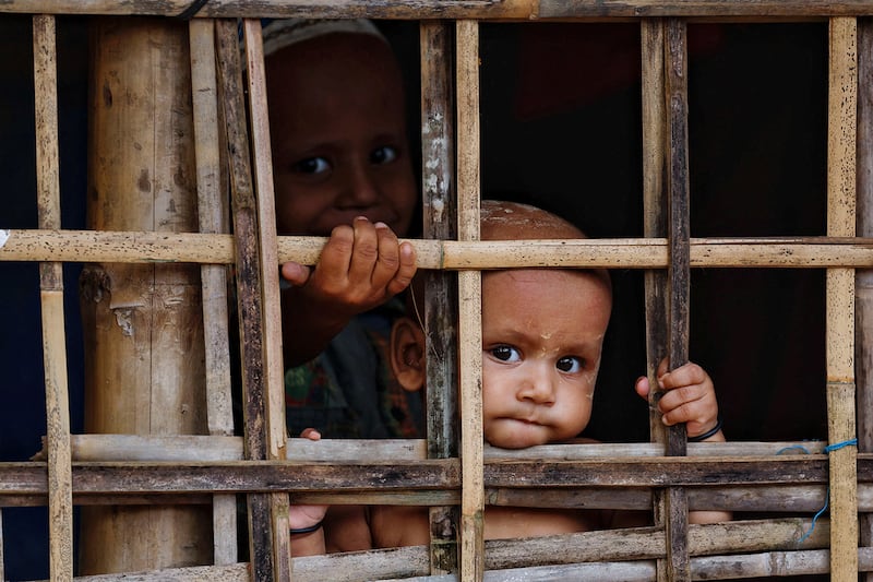 Rohingya refugee children look on from their shelter at a refugee camp in Cox\'s Bazar, Bangladesh, Sept. 28, 2024.