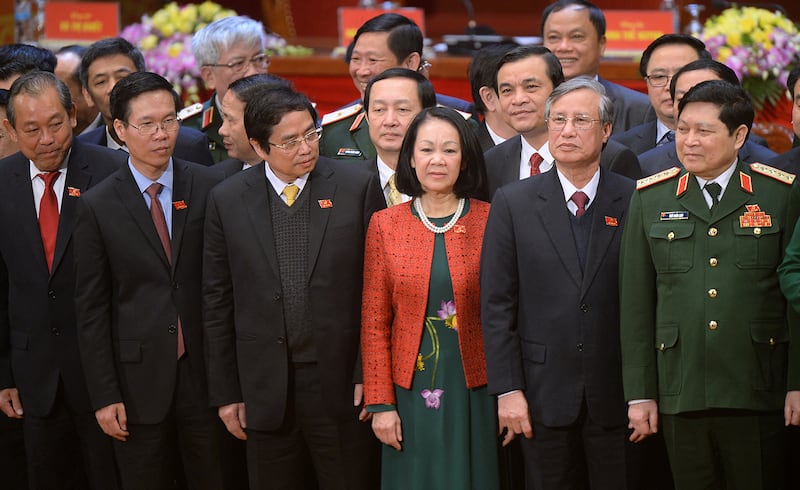 Newly elected Politburo members (L to R) Truong Hoa Binh, Vo Van Thuong, Pham Minh Chinh, Truong Thi Mai, Tran Quoc Vuong and Ngo Xuan Lich pose on the podium along with other new members of the Vietnam Communist Party\'s central committee at the closing ceremony on the final day of the 12th National Congress of Vietnam\'s Communist Party in Hanoi on January 28, 2016. Vietnam\'s top communist leader Nguyen Phu Trong was re-elected on January 27 in a victory for the party\'s old guard which some fear could slow crucial economic reforms in the fast-growing country. AFP PHOTO / POOL / HOANG DINH Nam (Photo by HOANG DINH NAM / POOL / AFP)