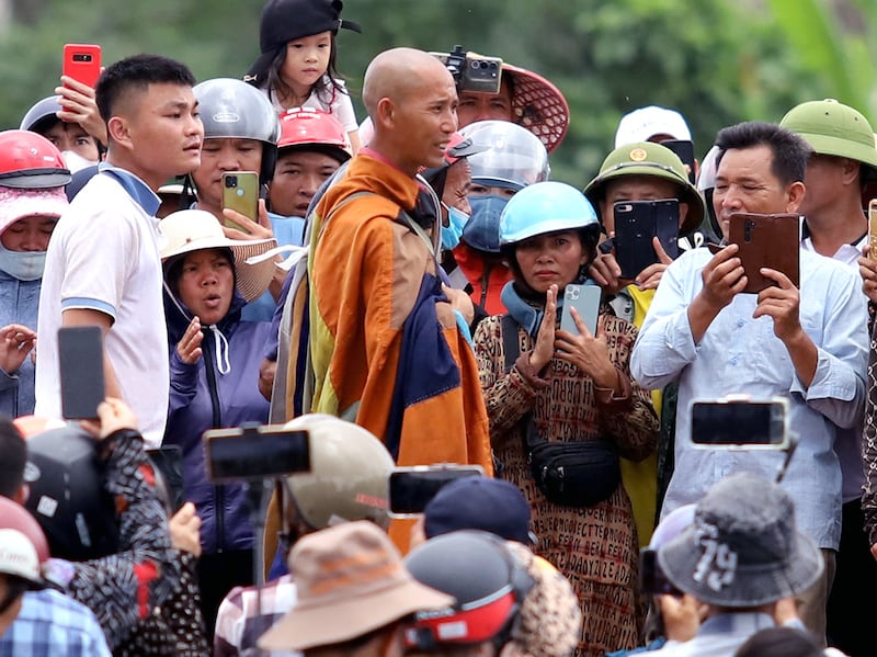 Buddhist monkl Thich Minh Tue, center, stands with local residents in Vietnam\'s Ha Tinh province on May 17, 2024. (AFP Photo)